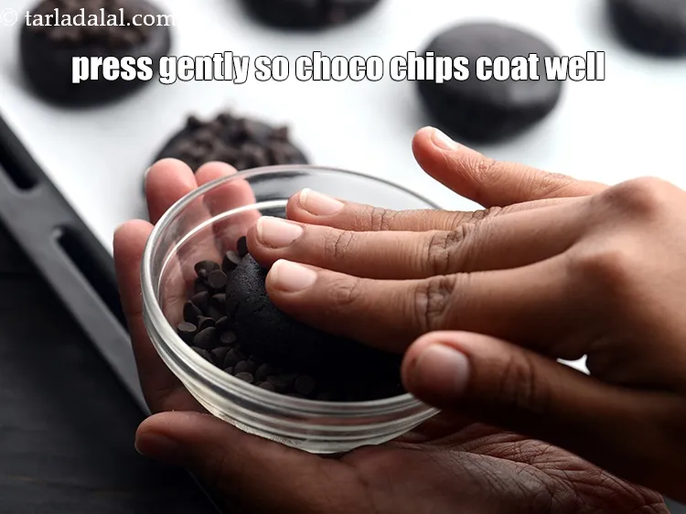 Step 16 – Take some chocochips in a small bowl and put one side of the cookie. Press …