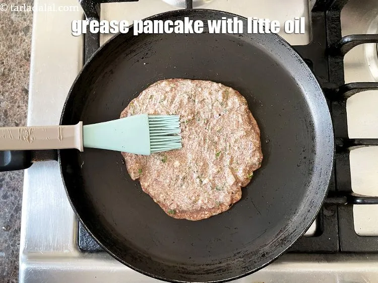 Step 20 – Grease the top of the nachni pancake.