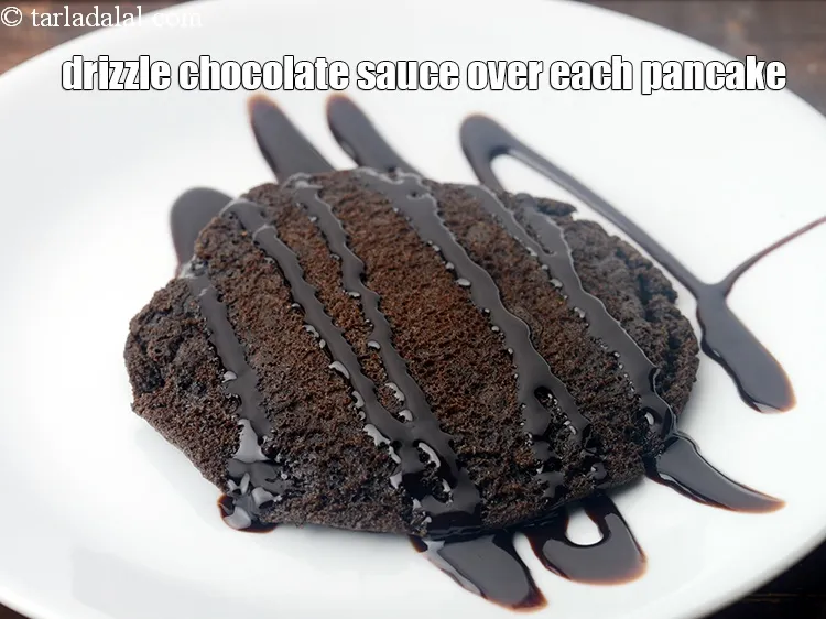 Step 18 – Drizzle 1 tbsp <a href="https://www.tarladalal.com/glossary-chocolate-sauce-1989i">chocolate sauce</a> over each pancake.