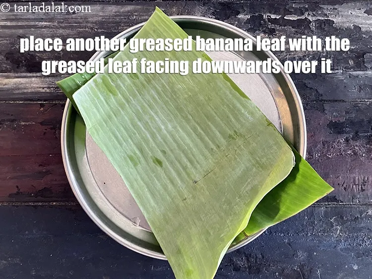 स्टेप 21 – एक और चिकना किया हुआ केले का पत्ता उसके ऊपर …
