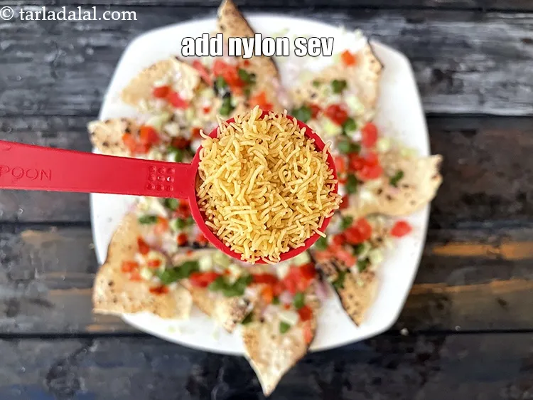 स्टेप 18 – हर खिचिया पापड़ में 1 टेबल-स्पून&nbsp;<a href=""https://www.tarladalal.com/glossary-nylon-sev-hindi-2630i"">नायलॉन सेव</a>&nbsp;डालें&nbsp;। आप अपनी …