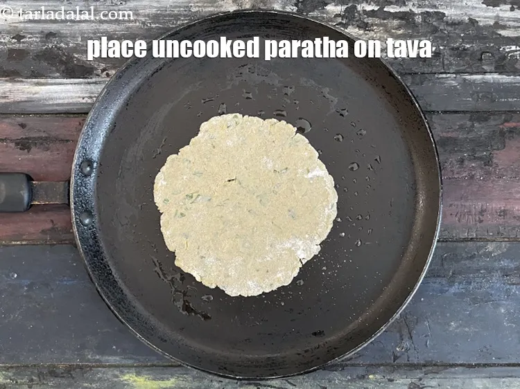Step 20 – <meta charset="UTF-8" /> Place the paratha gently on the tava.&nbsp;