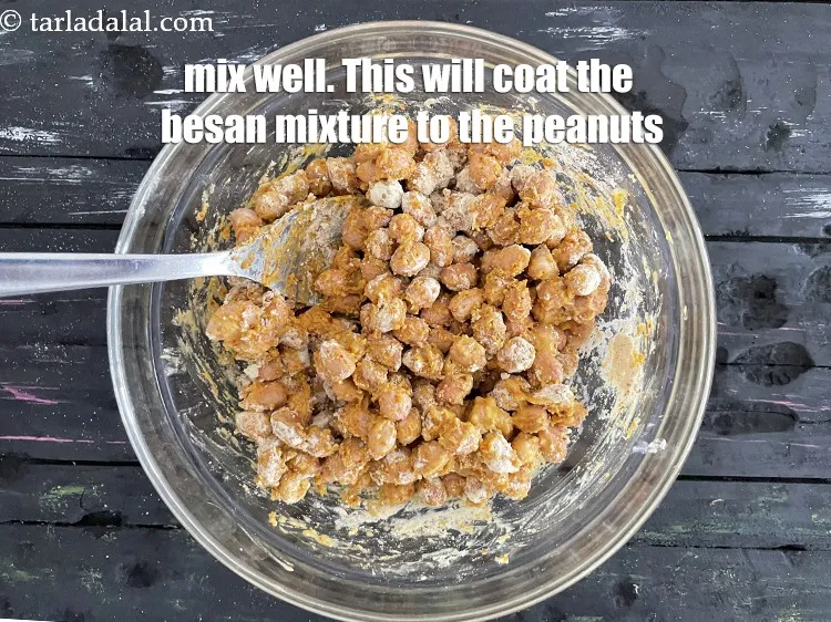 Step 19 – Mix well with a spoon.<u><em> This will help coat the besan mixture to the peanuts.</em></u>