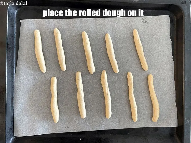 स्टेप 18 – बेले हुये ब्रेड स्टिक के आटे को ट्रे पर रखिये।
