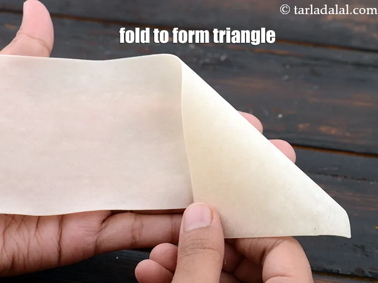 Step 18 – Fold the right top corner of the samosa patti on the opposite side to form …