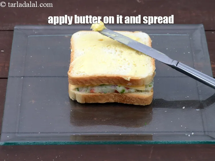 Step 18 – Apply &frac12; tsp of <a href="https://tarladalal.com/glossary-butter-makhan-233i">butter</a>&nbsp;on it and spread it evenly.