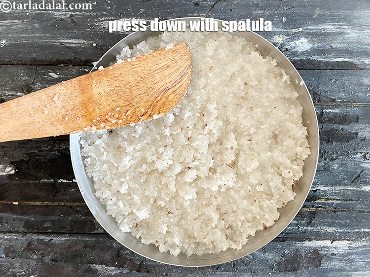 Step 29 – Press down nariyal vadi mixture with a spatula.&nbsp;