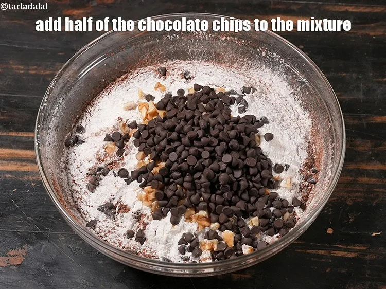 Step 19 – Add half of the <a href="https://www.tarladalal.com/glossary-chocolate-chips-325i">chocolate chips</a> to the mixture.