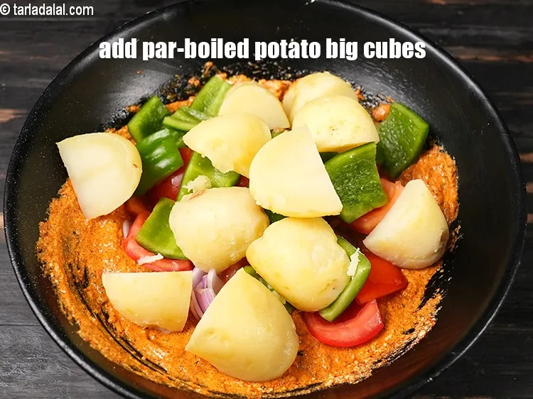 Step 20 – Add &frac12; cup <a href="https://www.tarladalal.com/glossary-parboiled-potato-cubes-2420i">par-boiled potato big cubes</a>.