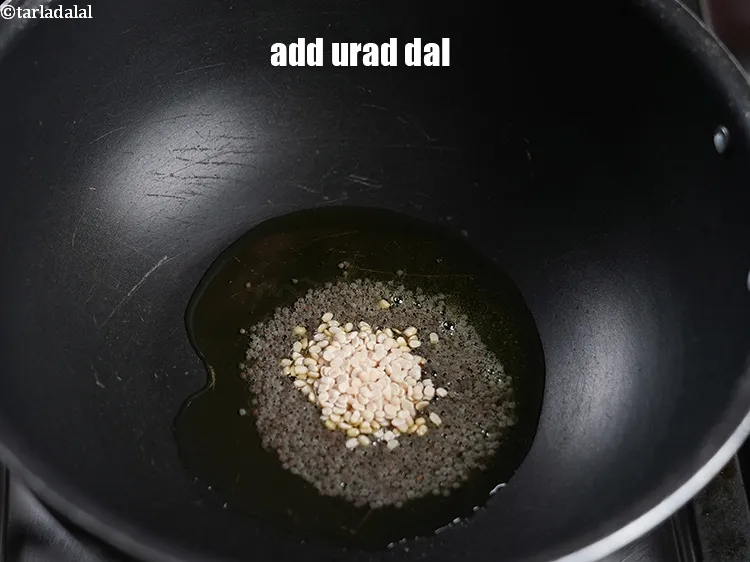 स्टेप 19 – जब बीज चटकने लगे तो १ टी-स्पून&nbsp;<a href=""https://www.tarladalal.com/glossary-urad-dal-split-black-lentil-hindi-941i"">उड़द दाल</a>&nbsp;डालें ।