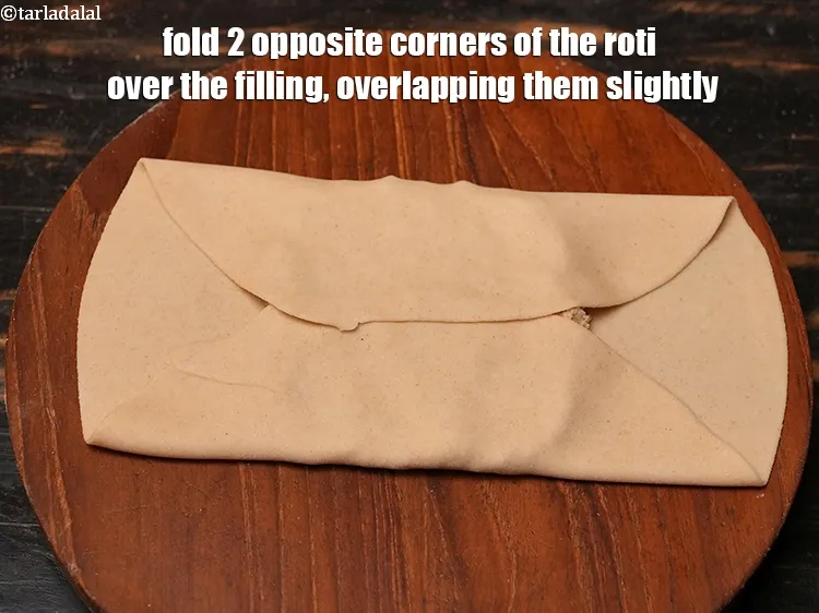 Step 27 – Fold 2 opposite corners of the roti over the filling, overlapping them slightly.
