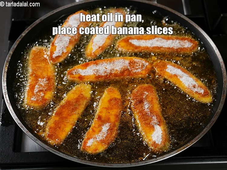 स्टेप 19 – एक चौड़े पैन में तेल गरम करें, उसमें लेपित केले …