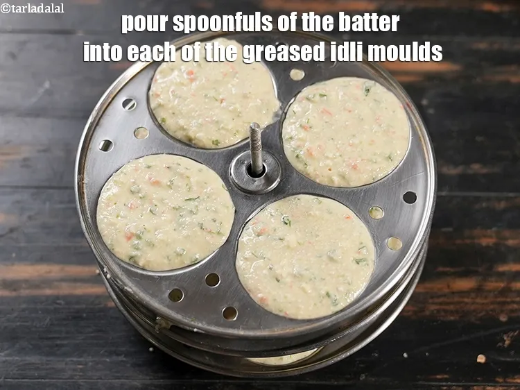 Step 19 – Pour spoonfuls of the batter into each of the greased idli moulds.