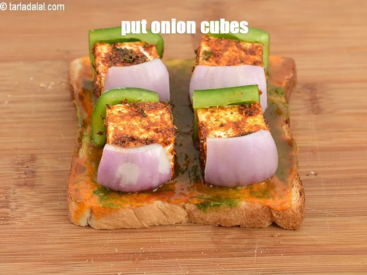 Step 19 – Put a <a href="https://www.tarladalal.com/glossary-onion-cubes-732i">onion cubes</a>&nbsp;on another side of the paneer.&nbsp;