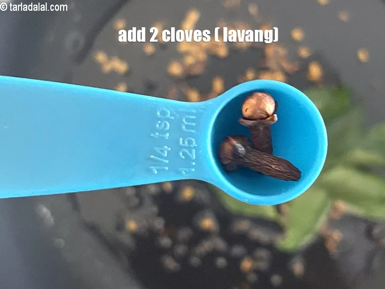 Step 19 – <p>Add 2 <a href="https://www.tarladalal.com/glossary-cloves-laung-lavang-322i"><strong>cloves (laung / lavang)</strong></a><strong>.</strong></p>