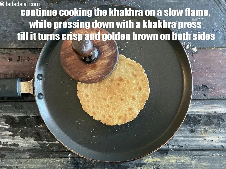 Step 20 – <meta charset="UTF-8" />Continue cooking the&nbsp;<strong>khakhra</strong>&nbsp;on a slow flame, while pressing with a&nbsp;<strong>khakhra</strong>&nbsp;press or a folded …