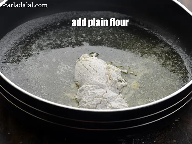 Step 22 – Add 1 tbsp <a href="https://www.tarladalal.com/glossary-plain-flour-maida-188i">plain flour (maida)</a>.