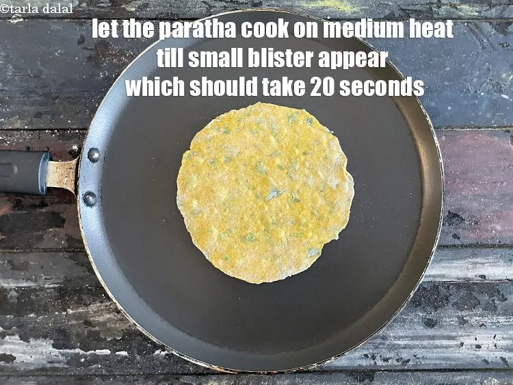 Step 19 – <meta charset="UTF-8" /> Let the paratha cook on medium flame till small bubbles appear on …