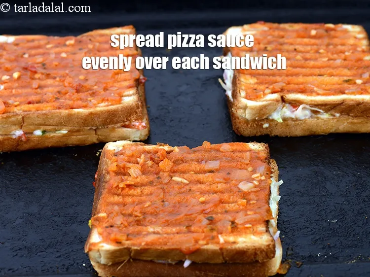 Step 19 – Spread 2 tsp of <a href="https://www.tarladalal.com/glossary-pizza-sauce-1889i">pizza sauce</a> evenly over each sandwich.