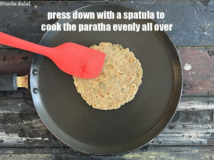 Step 20 – Press down with a spatula to cook the paratha evenly all over.