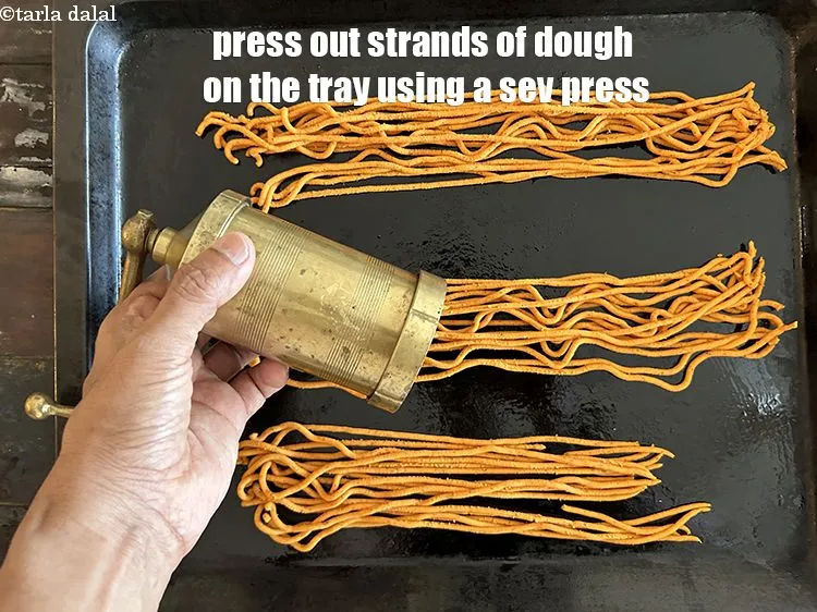 Step 25 – Press out strands of dough on the&nbsp;baking tray using a sev press.