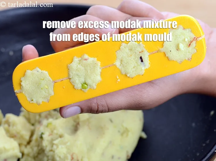 Step 19 – Remove the excess modak mixture from the edges of the modak mould.