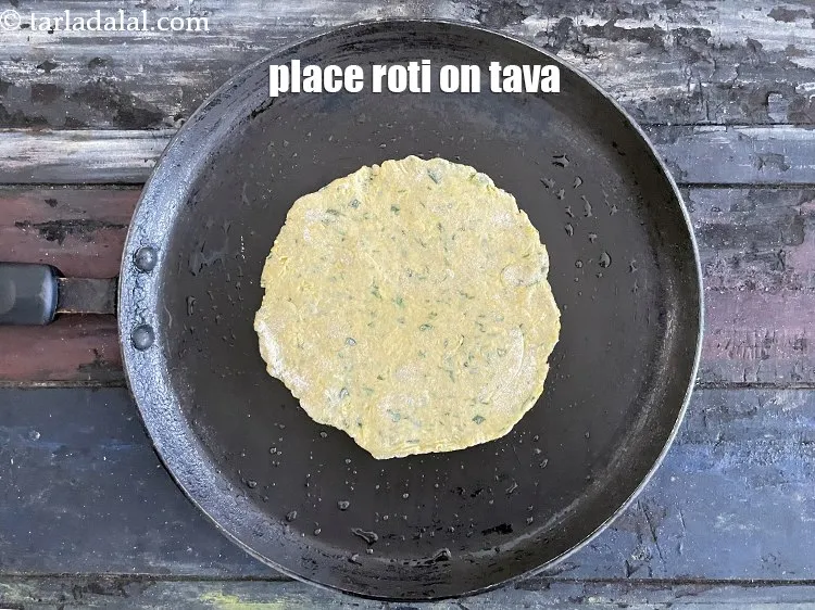 Step 22 – <meta charset="UTF-8" />Place the roti gently on the tava.&nbsp;