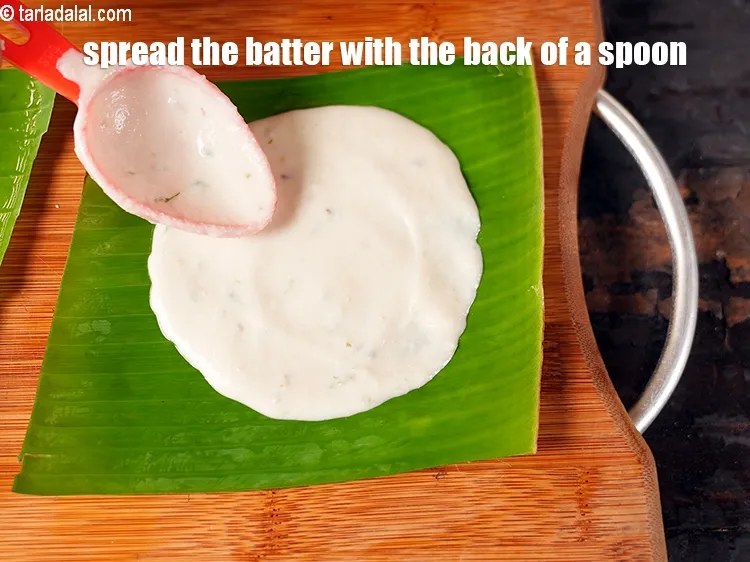 Step 28 – <meta charset="UTF-8" />Spread the batter with the back of a spoon on the banana leaf.&nbsp;&nbsp;&nbsp;
