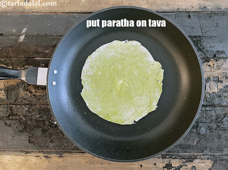 स्टेप 42 – बेले हुए पराठे को तवे पर डालें।