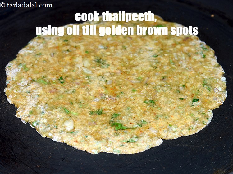 Step 20 – Cook the thalipeeth, using &frac14; tsp of oil till golden brown spots appear from both …