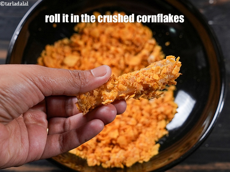Step 20 – Roll it well in&nbsp;the crushed cornflakes till it is evenly coated from all the sides.