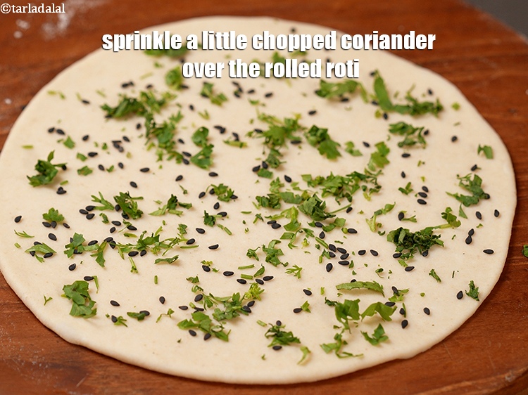 स्टेप 20 – बेली हुई रोटी के ऊपर&nbsp;थोड़ा&nbsp;&nbsp;<a href=""https://www.tarladalal.com/glossary-chopped-coriander-hindi-783i"">कटा हुआ हरा धनिया</a>&nbsp;छिड़कें&nbsp;&nbsp;।<br /> …
