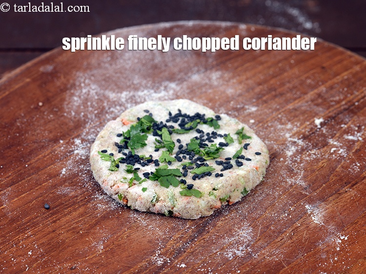 Step 20 – Sprinkle 1/4 tsp&nbsp;finely&nbsp;<a href="https://www.tarladalal.com/glossary-chopped-coriander-783i">chopped coriander (dhania)</a>&nbsp;for rolling evenly over it.&nbsp;