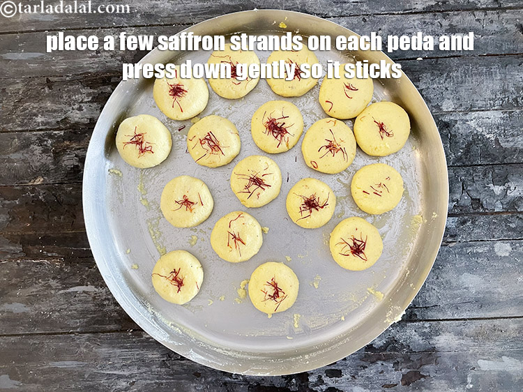 Step 21 – Place a few saffron strands on each peda. Press down gently so that the saffron …