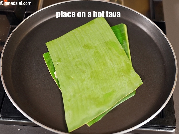 Step 23 – <meta charset="UTF-8" />Place banana leaf on a hot tava.&nbsp;&nbsp;&nbsp;