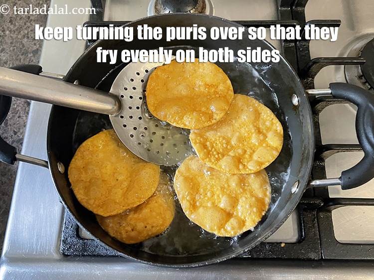 Step 20 – Keep turning the puris with a slotted spoon so that they fry evenly on both …