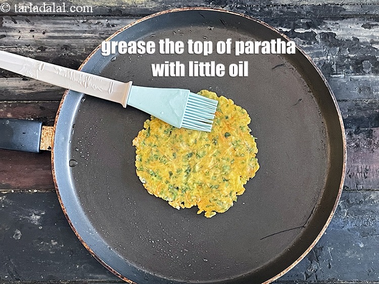 Step 20 – <html><head><meta charset="UTF-8"> </head><body><p>Grease the top of the paratha with oil.&nbsp;</p></body></html>
