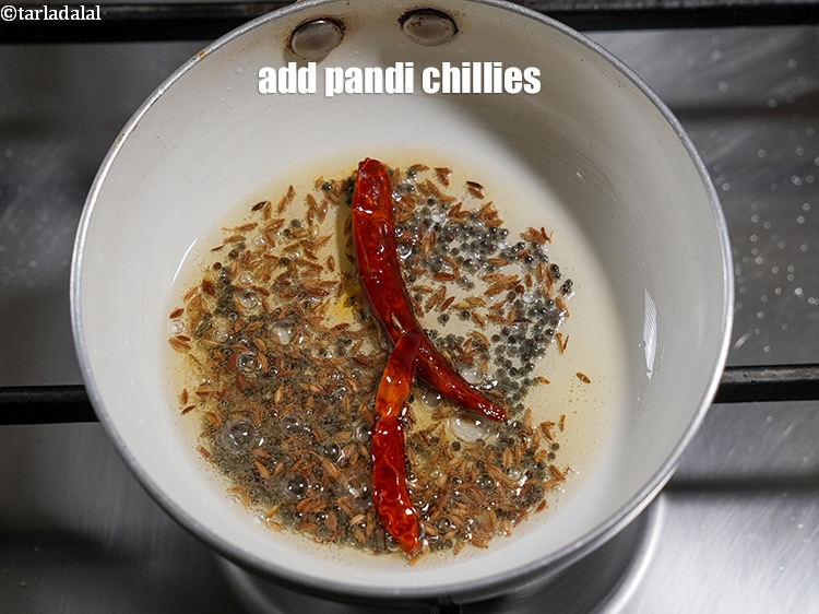 Step 23 – Add 2 <a href="https://www.tarladalal.com/glossary-pandi-chillies-pandi-dry-red-chillies-2373i">pandi chillies</a>.