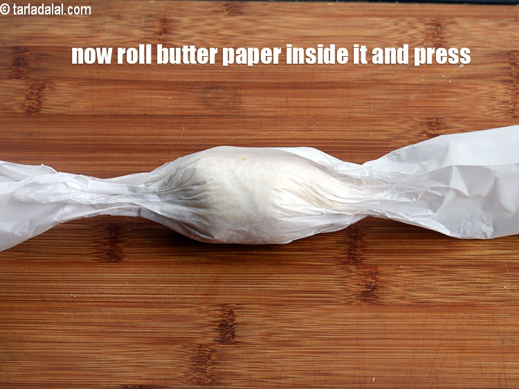 Step 21 – Now roll the butter paper while rolling the bread placed inside it and press on …