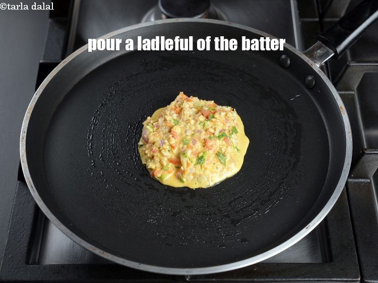 Step 21 – Pour a ladleful of the batter on the tava (griddle).