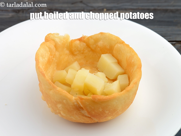 Step 23 – Put 1 tbsp <a href="https://www.tarladalal.com/glossary-boiled-and-chopped-potatoes-1879i">boiled and chopped potatoes</a> in the depression.