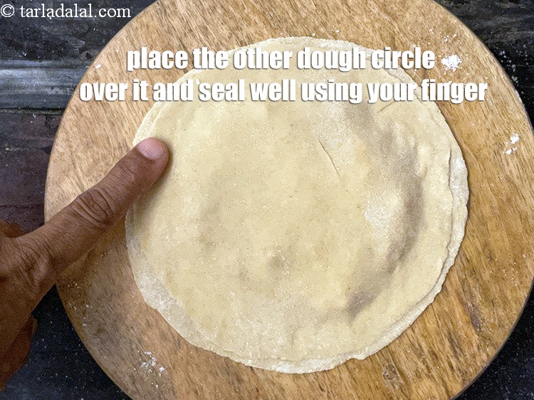 Step 40 – Pinch the sides to seal the paratha between your thumb and any finger.
