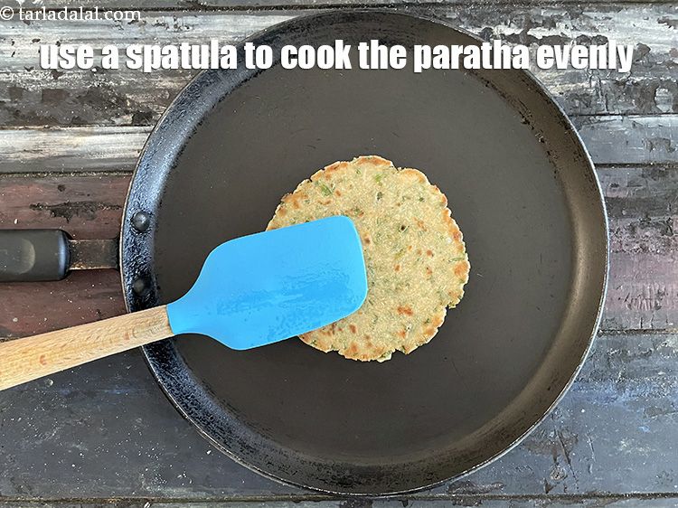 Step 27 – Use a spatula to press down on the paratha to cook it evenly.
