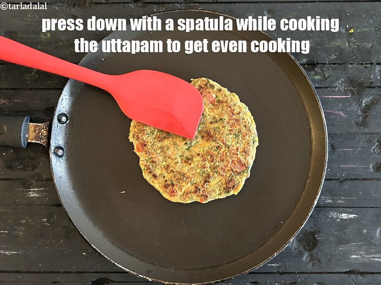 Step 22 – Press down with a spatula while cooking the uttapam to get even cooking.