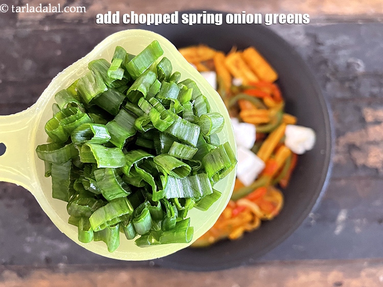 स्टेप 21 – १/२ कप <a href=""https://www.tarladalal.com/glossary-chopped-spring-onion-greens-hindi-1030i"">कटी हुई हरी प्याज़ के पत्ते</a> डालें।