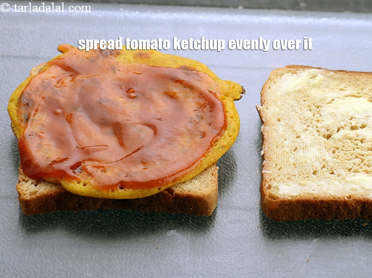 Step 21 – Spread 1 tbsp of <a href="https://www.tarladalal.com/glossary-tomato-ketchup-tomato-sauce-181i">tomato ketchup</a>&nbsp;onj the chila evenly over it