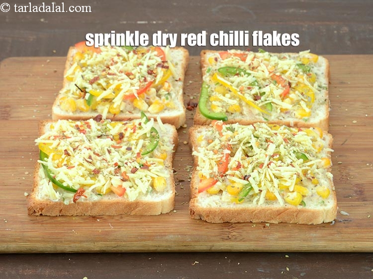 Step 21 – Sprinkle a little <a href="https://www.tarladalal.com/glossary-dry-red-chilli-flakes-paprika-338i">dry red chilli flakes (paprika)</a> evenly over each bread slice.