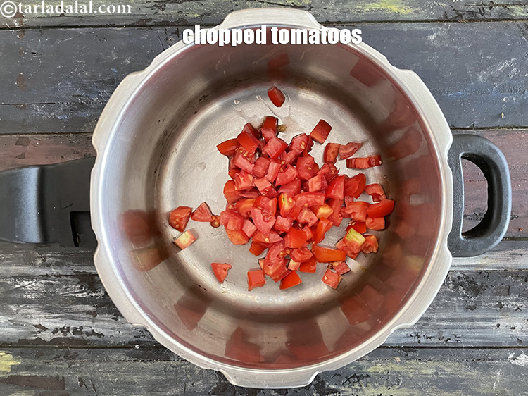 Step 14 – In a pressure cooker, put&nbsp;<meta charset="UTF-8" />1 cup&nbsp;<a href="glossary-chopped-tomatoes-779i">chopped tomatoes</a>.