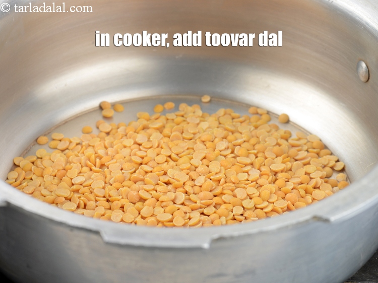 Step 4 – To make<strong> Dhansak dal</strong>, in a pressure cooker, add &frac12; cup <a href="https://www.tarladalal.com/glossary-toovar-dal-arhar-dal-toor-dal-split-pigeon-peas-tur-dal-955i">toovar (arhar) dal</a>&nbsp;.