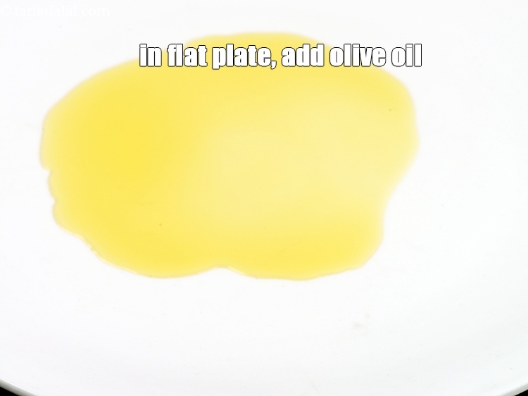 Step 3 – In a flat plate, add 1 &frac12; tbsp <a href="https://www.tarladalal.com/glossary-olive-oil-451i">olive oil</a>.